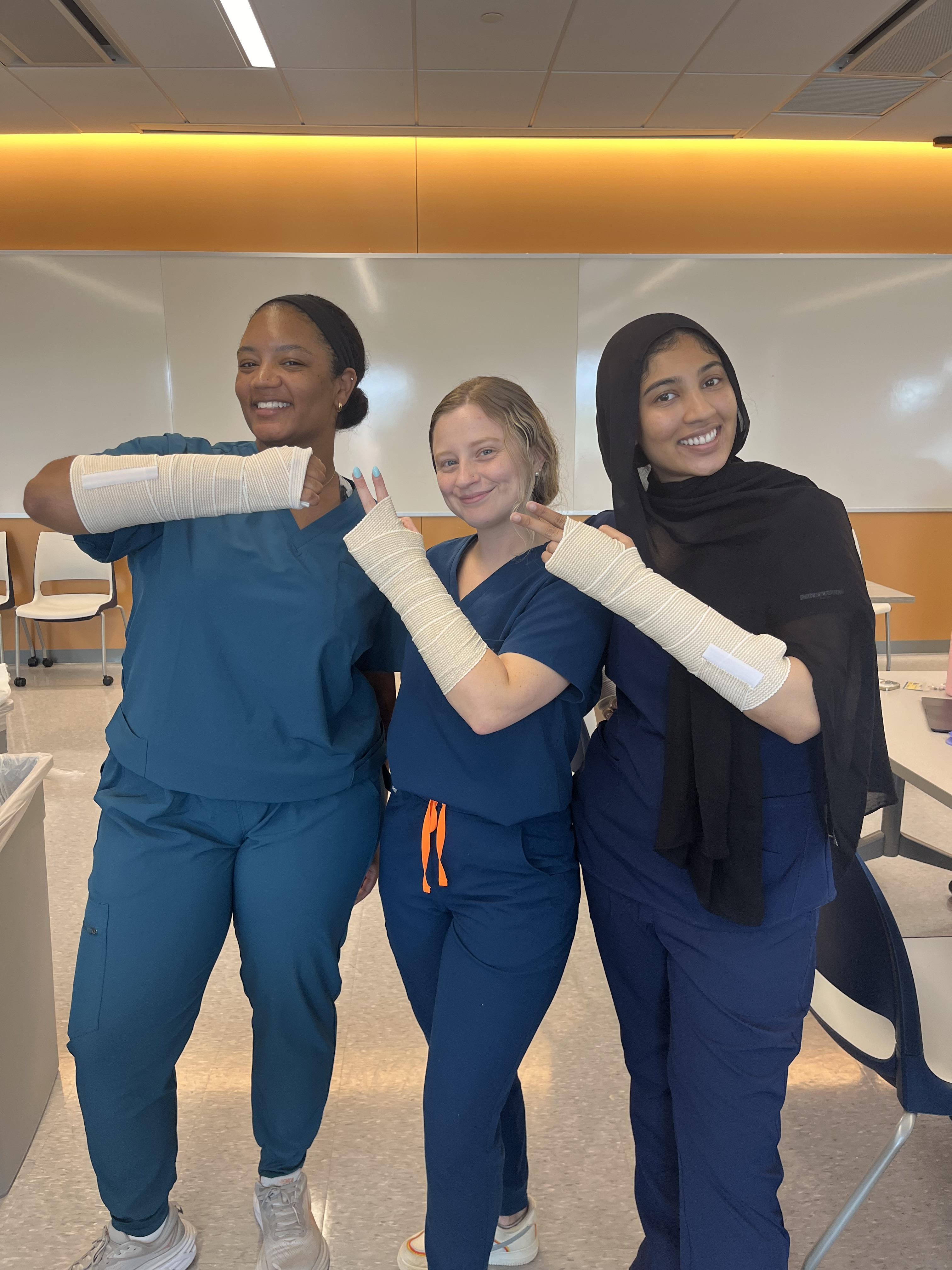 Hannah Brown with two PA students showcasing wrapped arms
